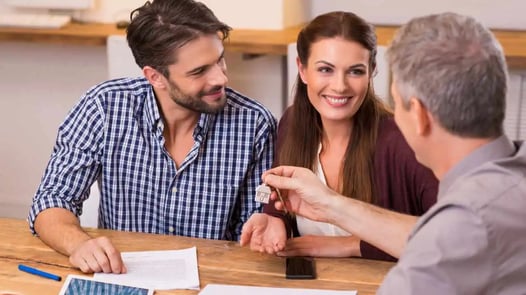 Pareja recibiendo llaves de una casa