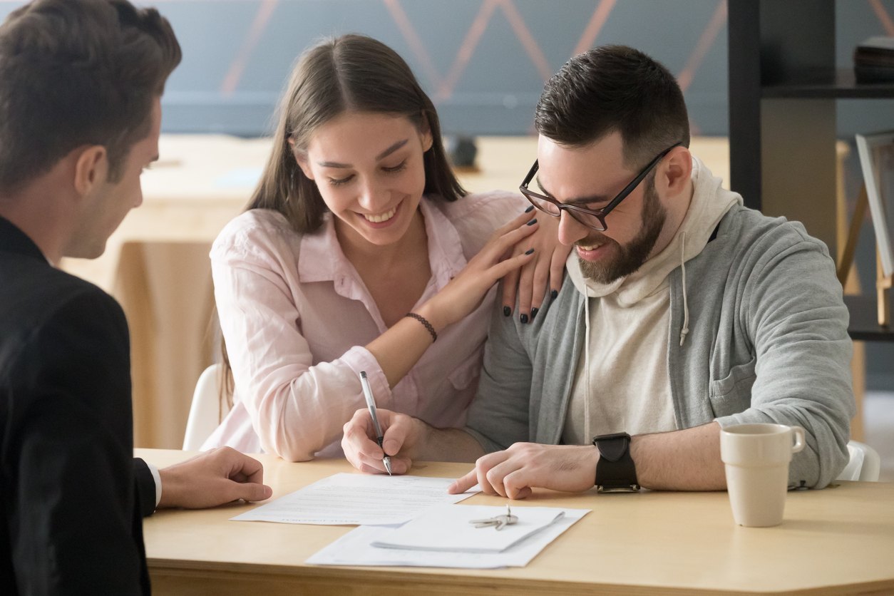 Pareja firmando una póliza de seguro de vivienda