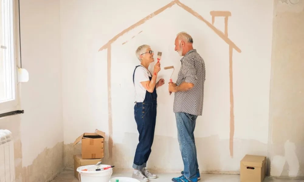 Pareja pintando una casa