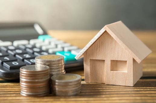 Monedas y casa sobre una mesa