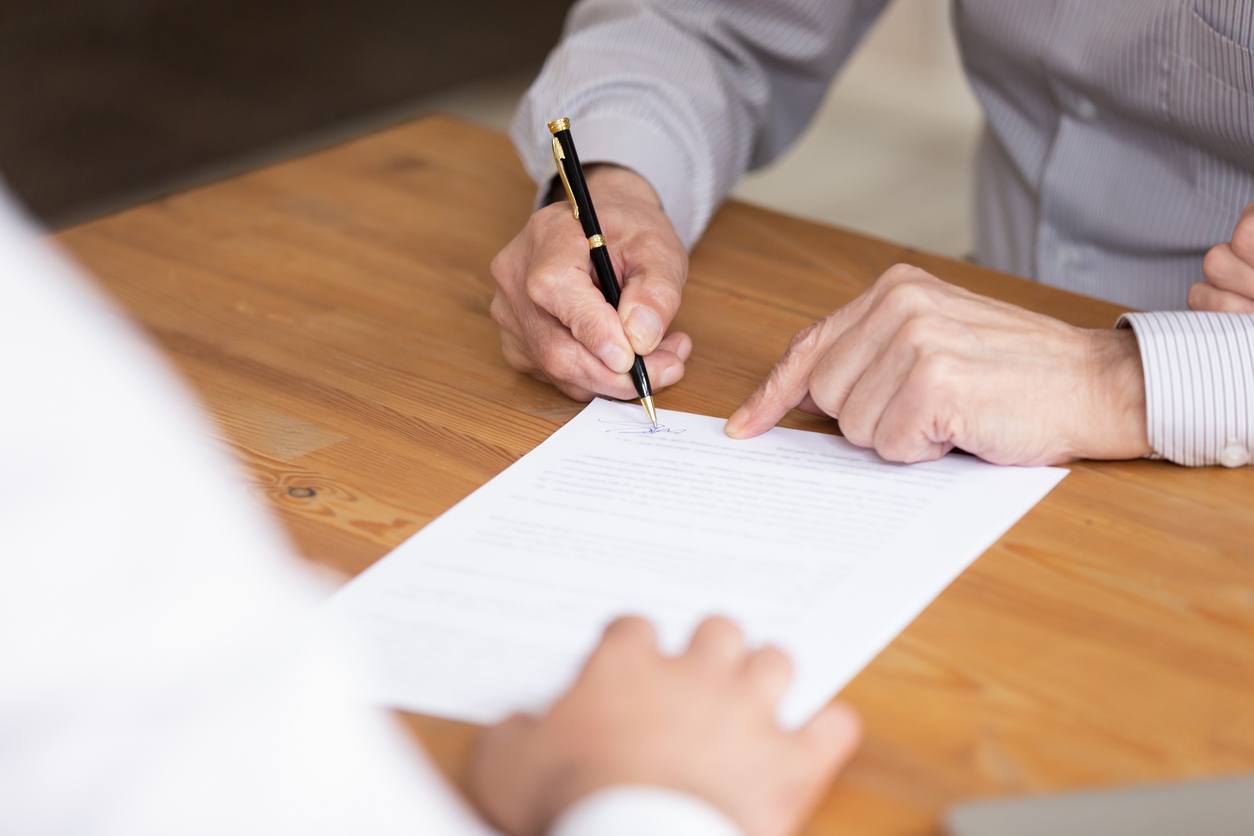 Persona firmando las escrituras al comprar una casa