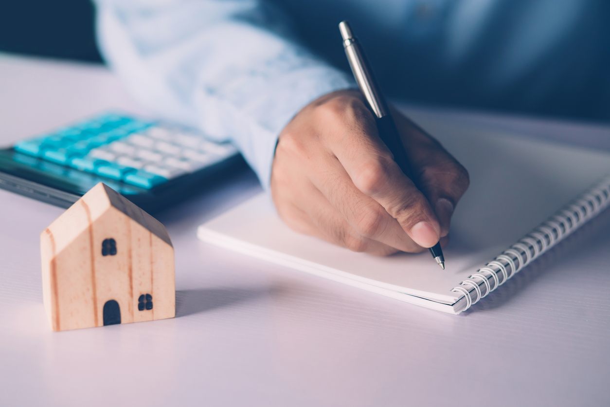 Persona calculando la tasa de refinanciamiento de una hipoteca