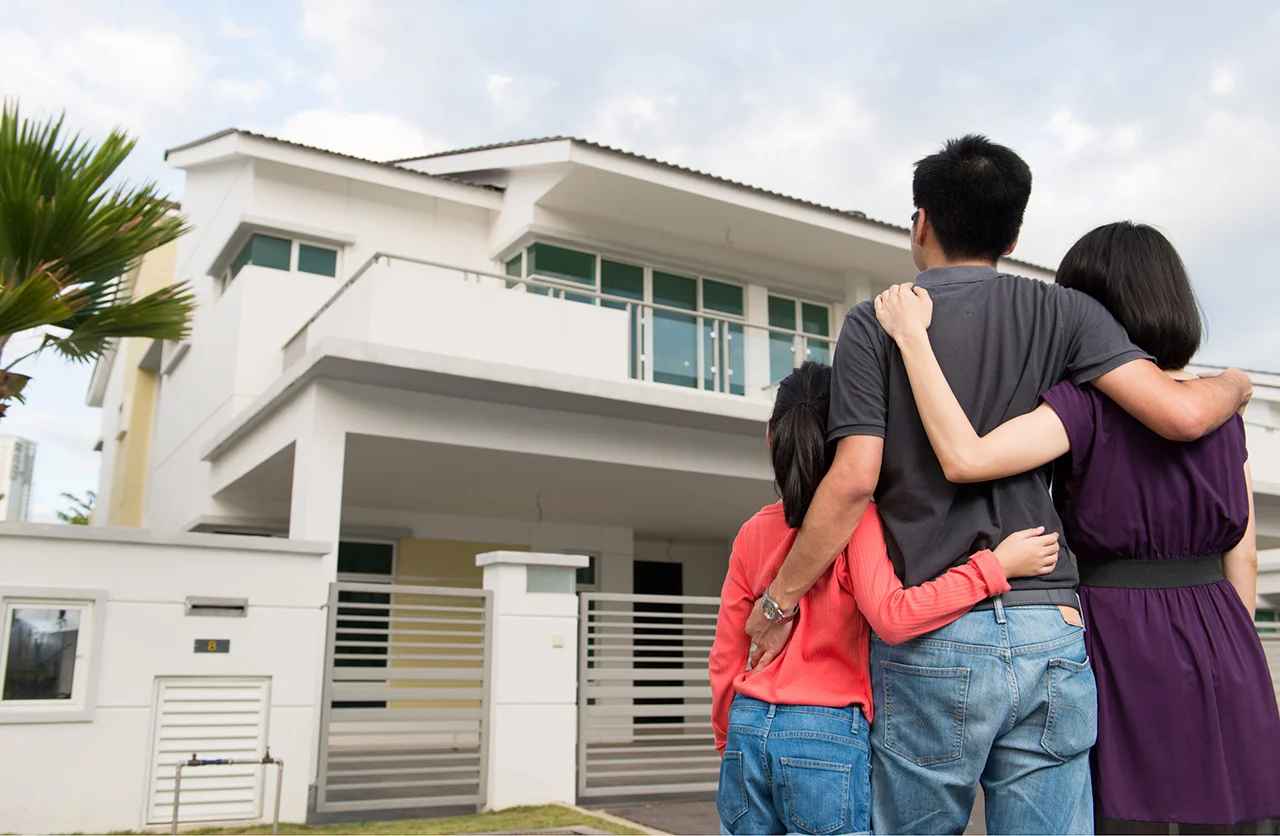 Familia en el exterior de una casa gracias a un crédito hipotecario