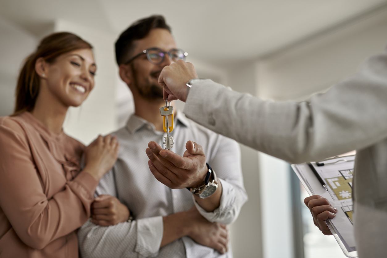 Pareja recibiendo llaves de una casa